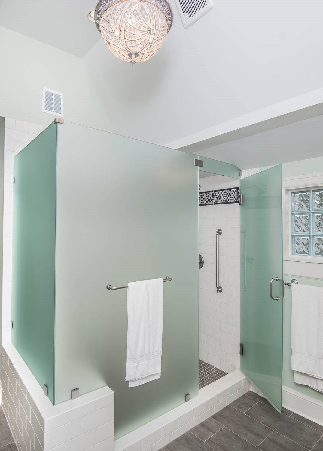 a fully satin etched shower, completely obscuring the interior, when the door opens it hits a towel bar