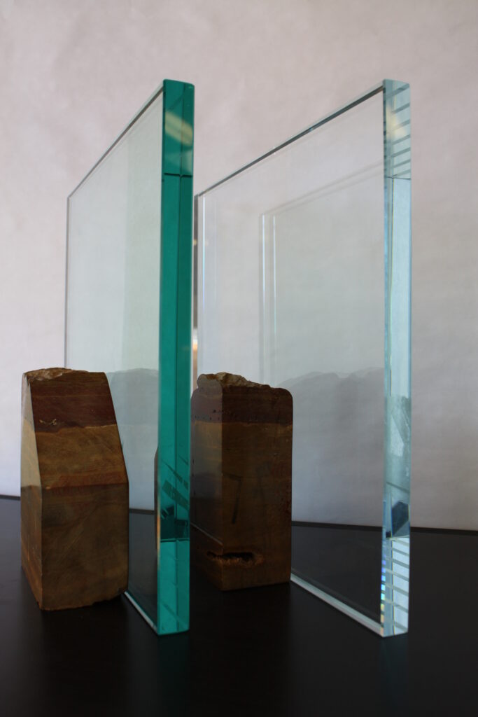 two small pieces of glass, the one on the left has a dark green edge, while the one on the right has a clearer blue edge