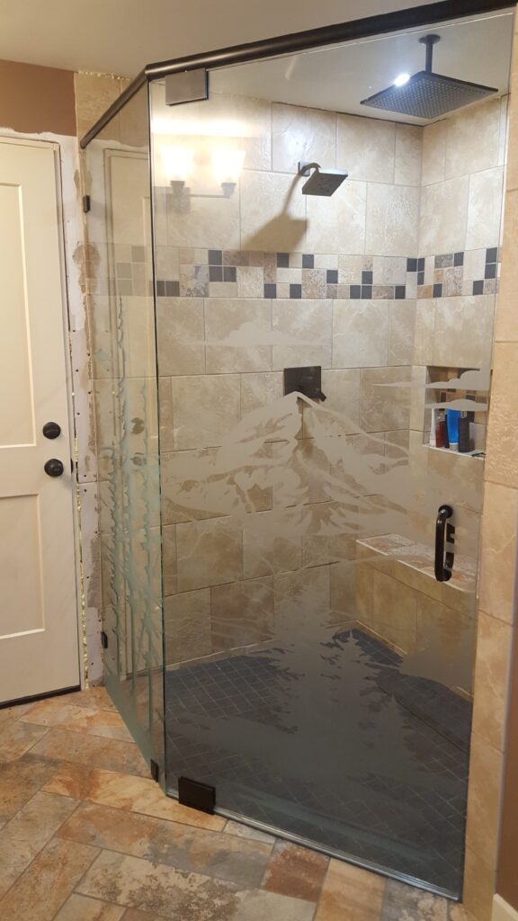 a shower with a picture of mount hood etched into the side