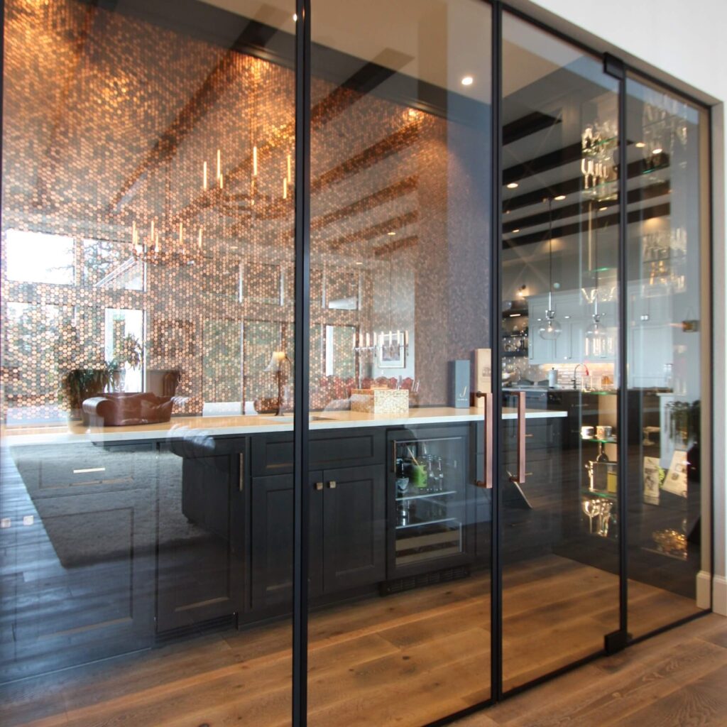 a large wine room with countertop and sink inside sealed with large doors and panels